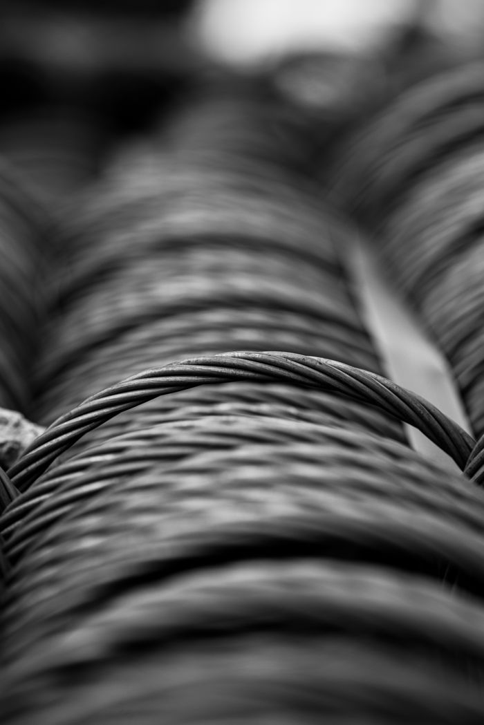 Detailed black and white close-up of coiled steel wire, showcasing texture and industrial craftsmanship.